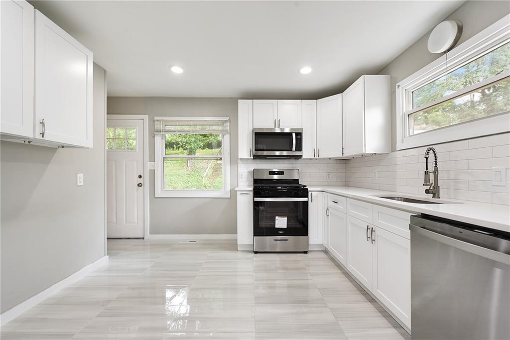 614 Springdale Drive Pittsburgh, PA 15235 - Photo 9 of 31 a kitchen with kitchen island granite countertop a stove cabinets and a sink