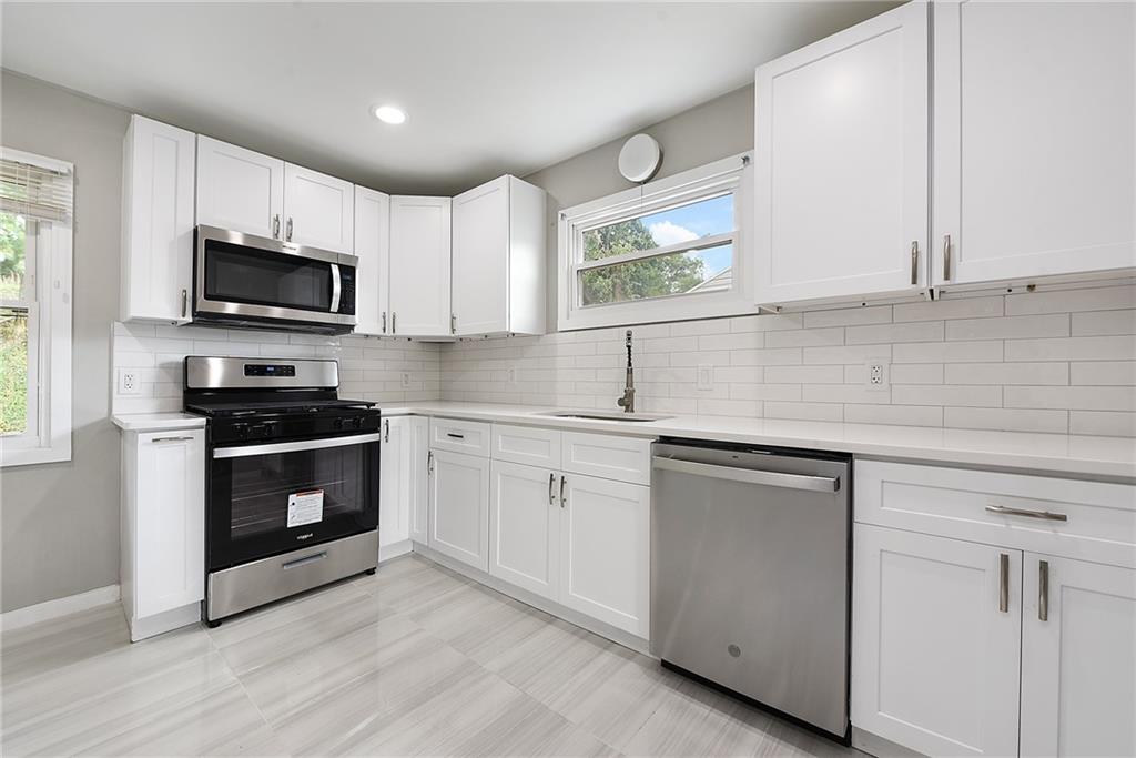 614 Springdale Drive Pittsburgh, PA 15235 - Photo 10 of 31 a kitchen with white cabinets stainless steel appliances and a window