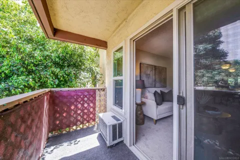 a view of a balcony with furniture and floor to ceiling window