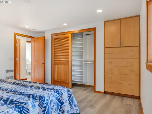 a bedroom with a bed and wooden floor