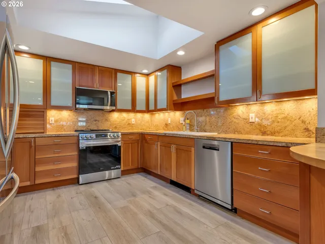 a kitchen with stainless steel appliances granite countertop a stove and a sink