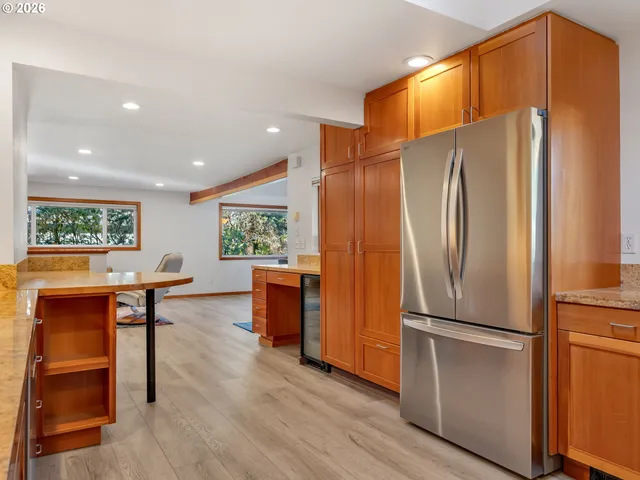 a kitchen with stainless steel appliances a refrigerator and wooden floor
