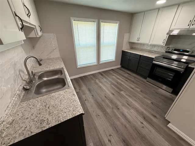a kitchen with a sink a stove and cabinets