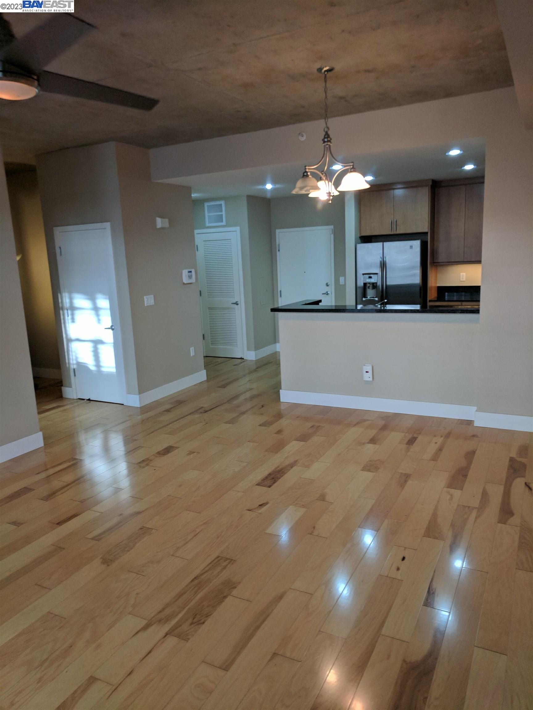 288 3rd Street, Unit 407 Oakland, CA 94607 - Photo 11 of 24 a view of a kitchen with granite countertop a refrigerator a oven a dining table and chairs