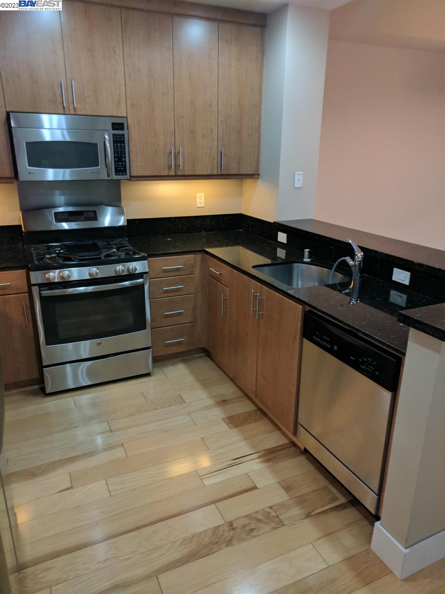 288 3rd Street, Unit 407 Oakland, CA 94607 - Photo 3 of 24 a kitchen with granite countertop a stove and a sink