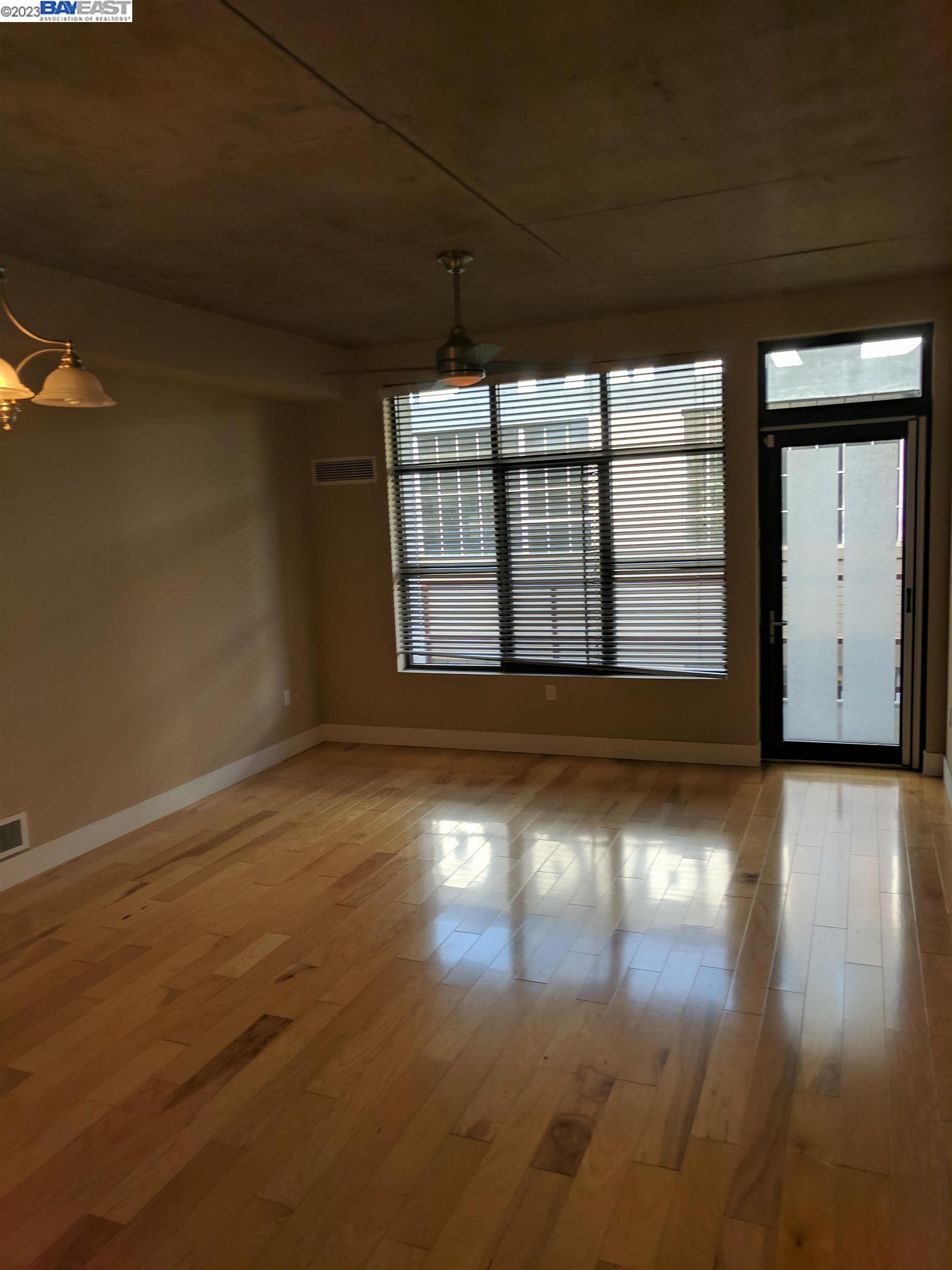 288 3rd Street, Unit 407 Oakland, CA 94607 - Photo 8 of 24 an empty room with wooden floor and windows