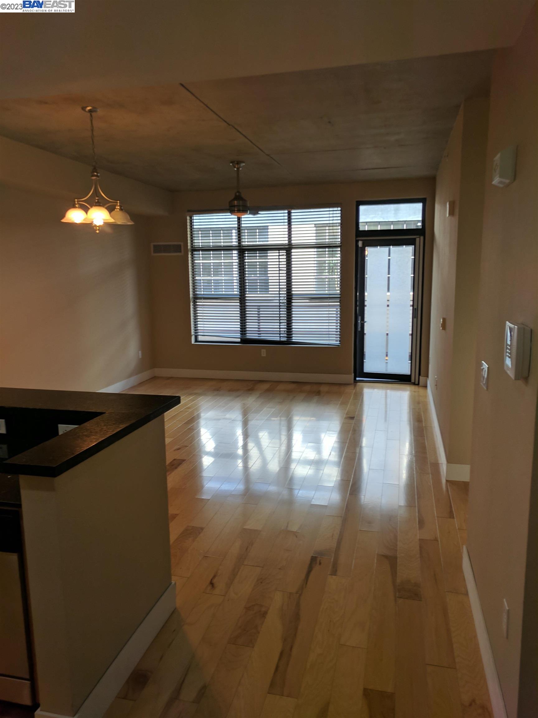 288 3rd Street, Unit 407 Oakland, CA 94607 - Photo 10 of 24 an empty room with wooden floor and windows