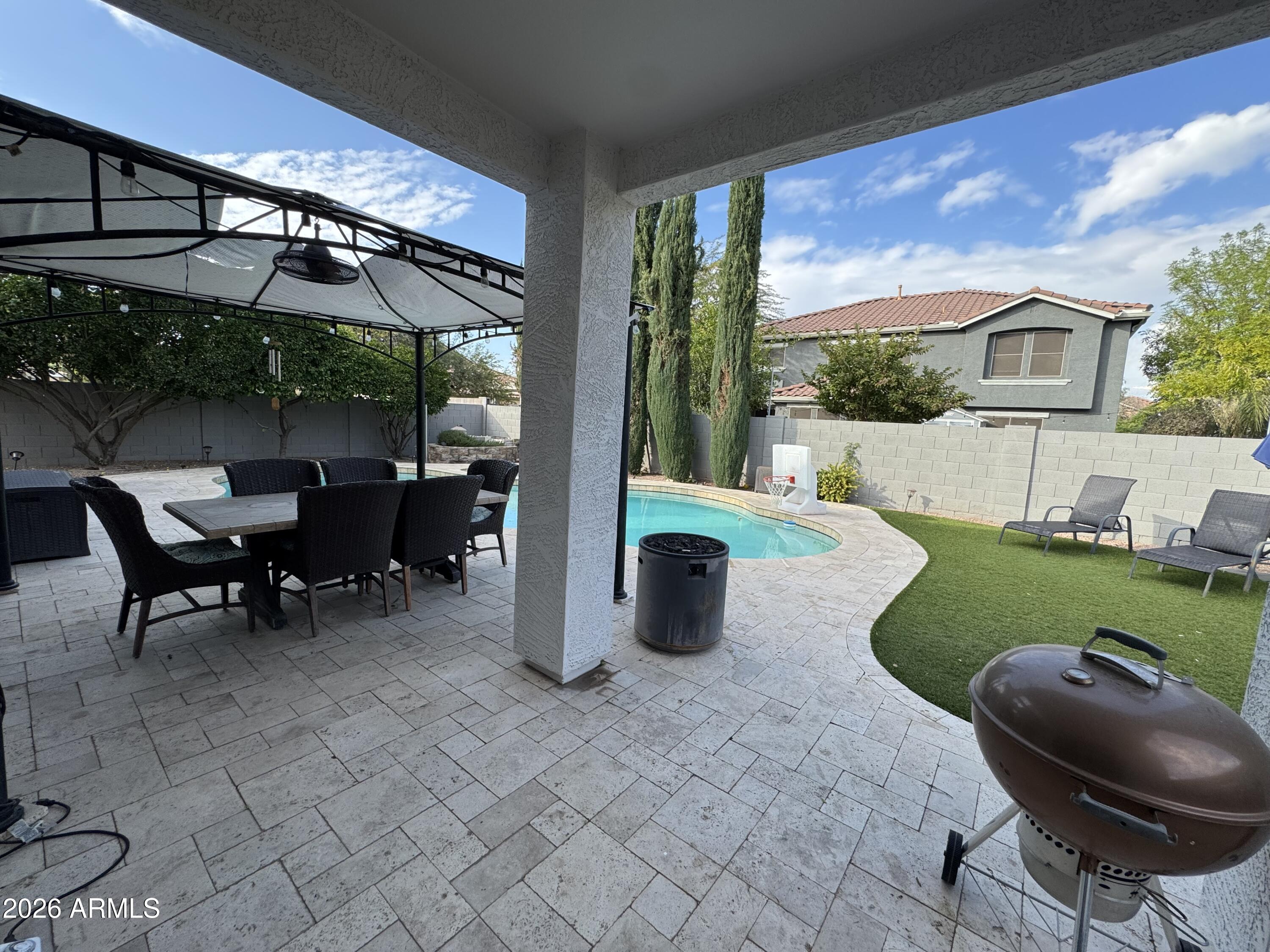 3750 East Orchid Lane Gilbert, AZ 85296 - Photo 38 of 43 a view of a patio with table and chairs potted plants with wooden floor and fence