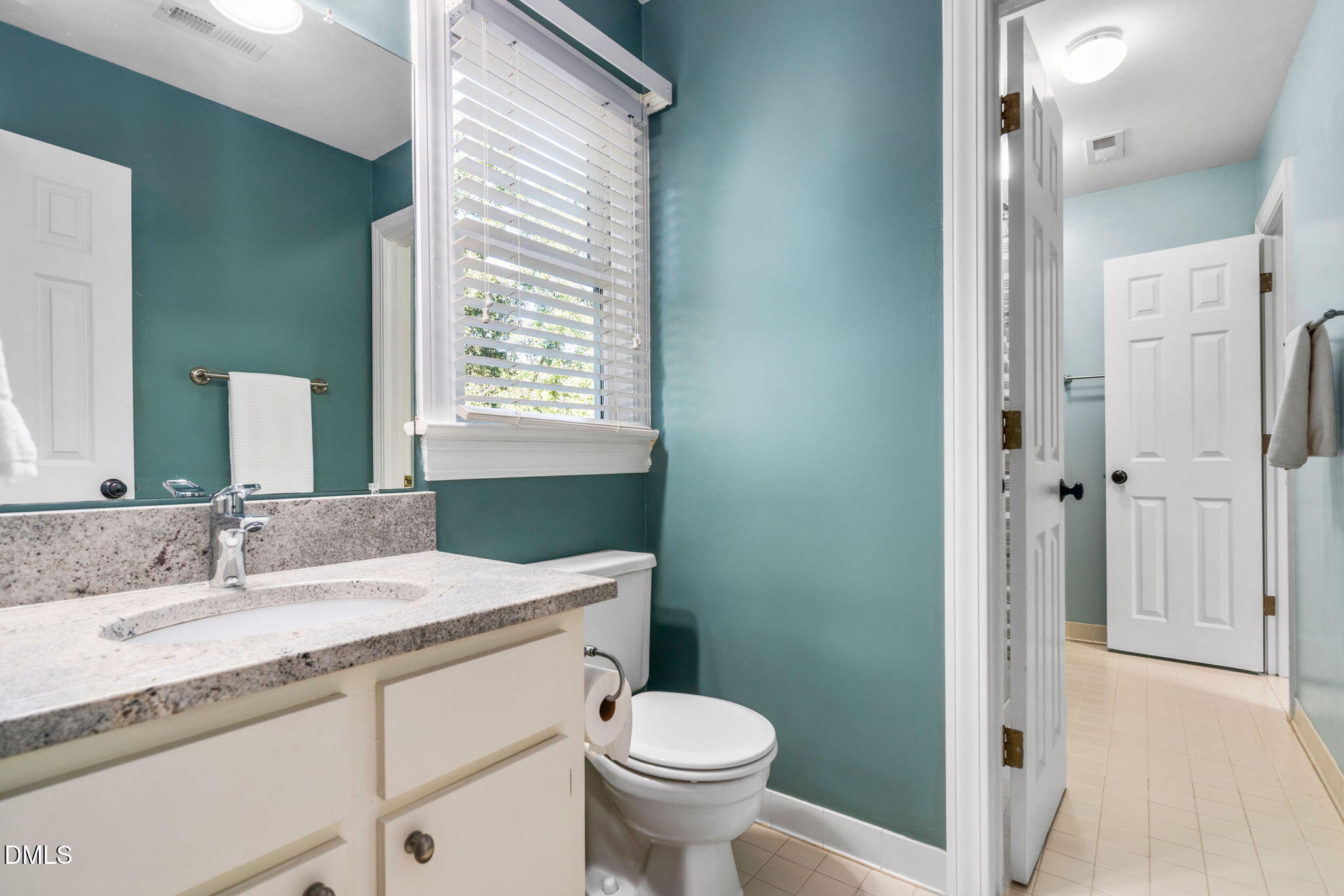 1405 October Road Raleigh, NC 27614 - Photo 20 of 40 a bathroom with a granite countertop toilet a sink and a mirror