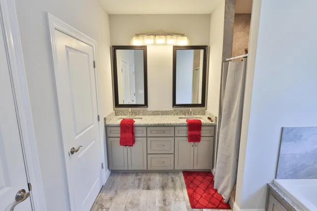 a bathroom with a tub sink and mirror
