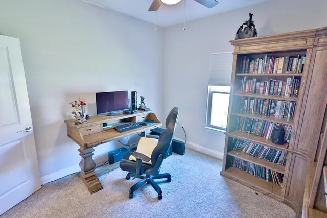 a view of a workspace with furniture and a bookshelf