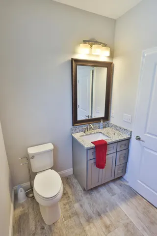 a bathroom with a granite countertop toilet and mirror