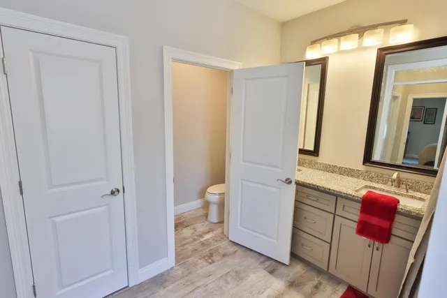 a bathroom with a granite countertop shower and a toilet