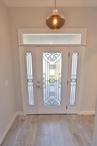 a view of a hallway with wooden floor and a bathroom