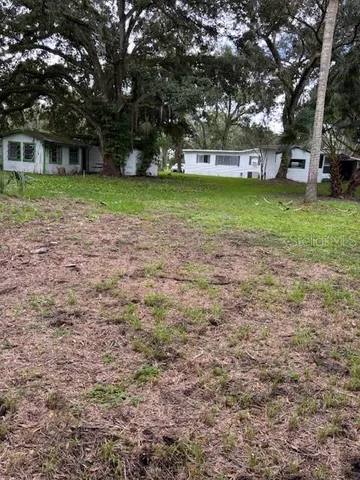 a view of a yard with a house in the background