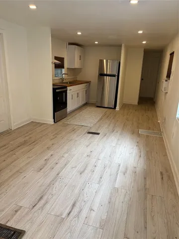 a view of kitchen with refrigerator microwave and wooden floor