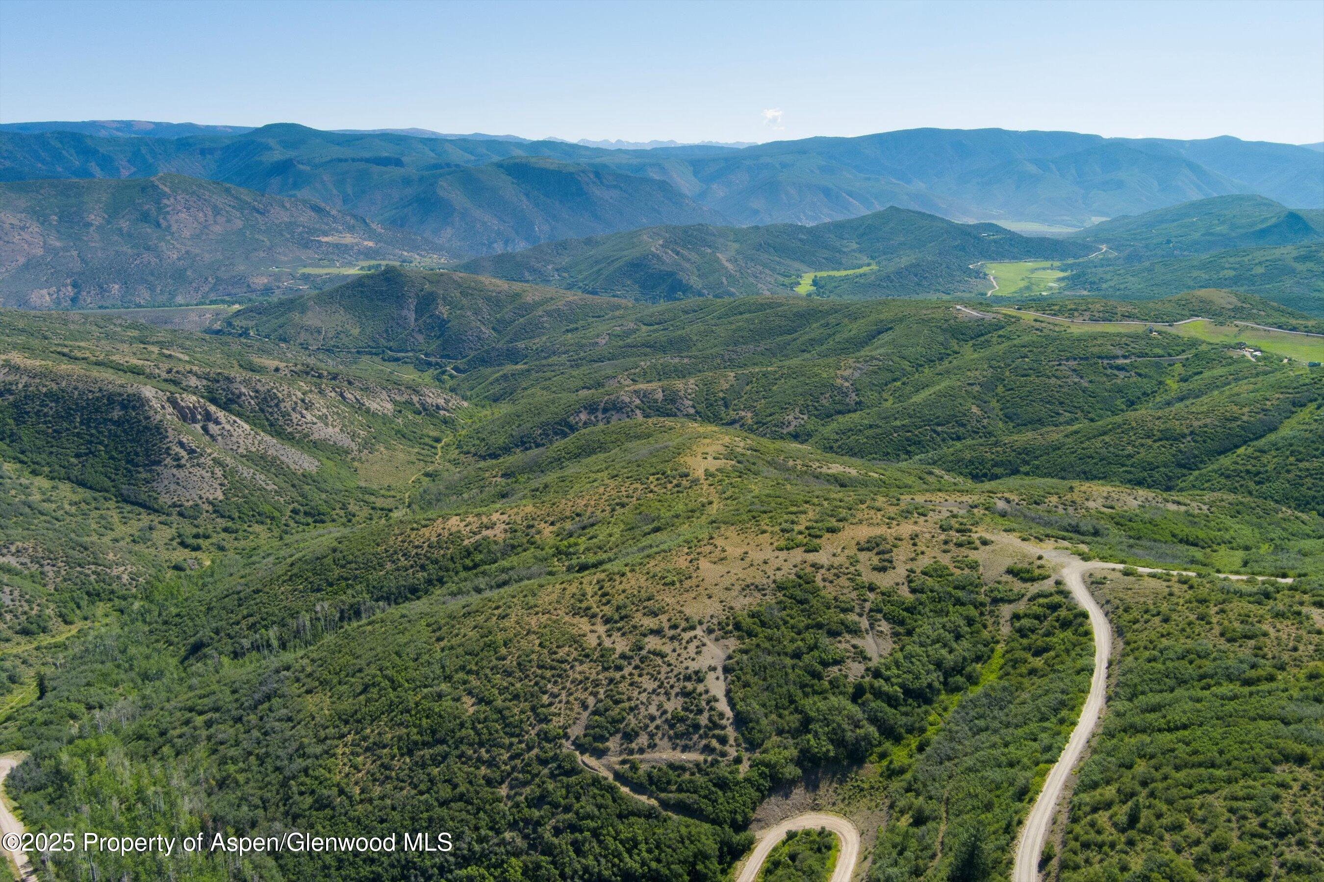 Tbd Monastery Road Snowmass, CO 81654 - Photo 9 of 26 a view of a lush green hillside and houses