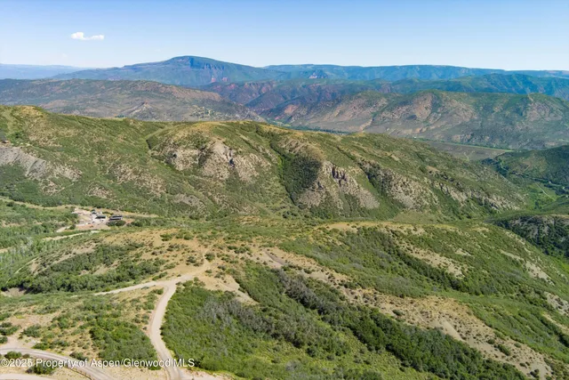 a view of a lush green hillside and houses