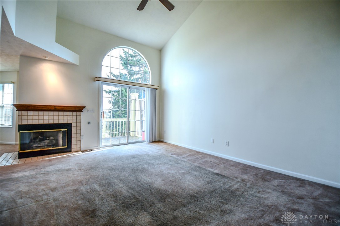 This airy living area features a fireplace and a balcony with an arched window above.