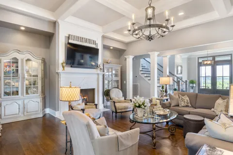 a living room with furniture a fireplace and a chandelier