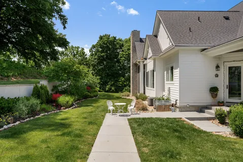 a kitchen with stainless steel appliances granite countertop a sink a stove a dining table and chairs