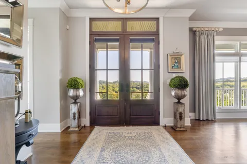 a living room with furniture chandelier and a large window