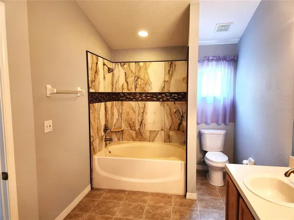 a bathroom with a bathtub and a toilet