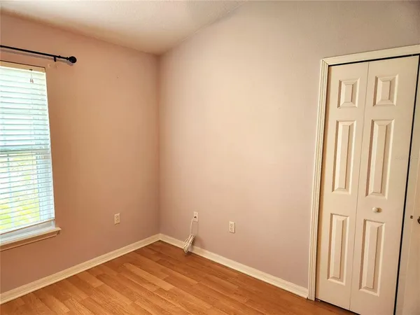 an empty room with wooden floor and a window