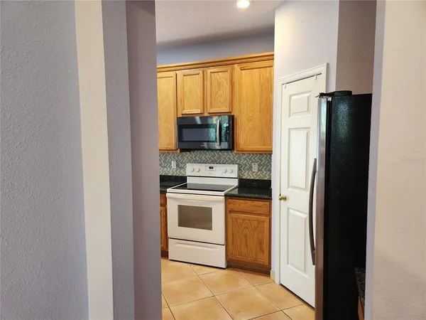 a kitchen with a stove top oven and refrigerator