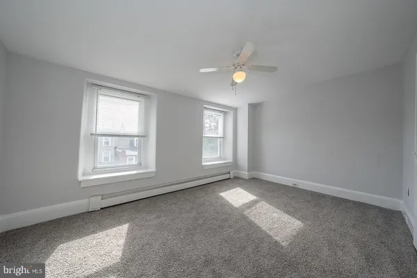 an empty room with a ceiling fan and a window