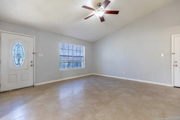 an empty room with windows and fan