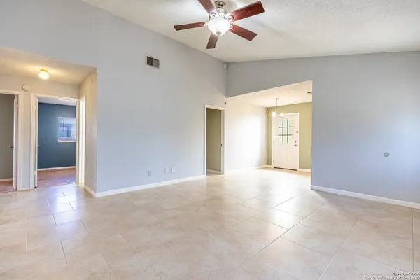 an empty room with fan and entrance