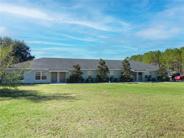a front view of house with yard and trees