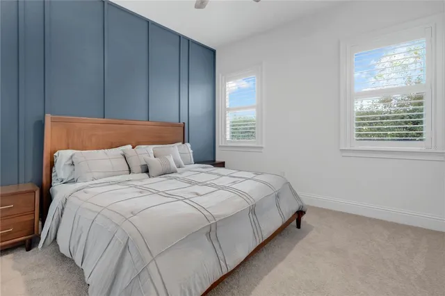 a large bed sitting in a bedroom next to a lamp