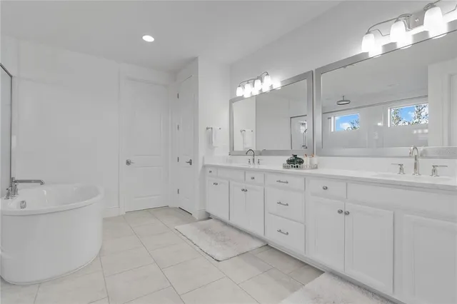 a bathroom with a granite countertop toilet a sink a mirror a shower and a window