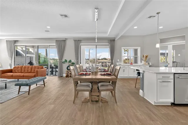 a view of a a dining room with furniture window and wooden floor