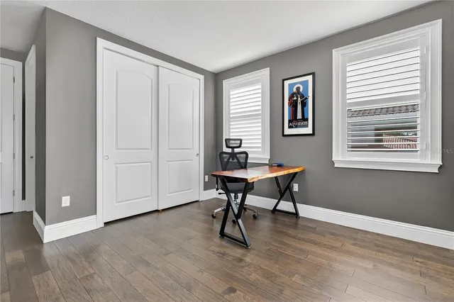 a kitchen with stainless steel appliances kitchen island granite countertop a table chairs in it and white cabinets