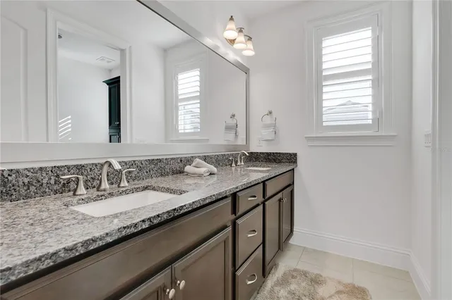 a view of a white house with a big yard and potted plants