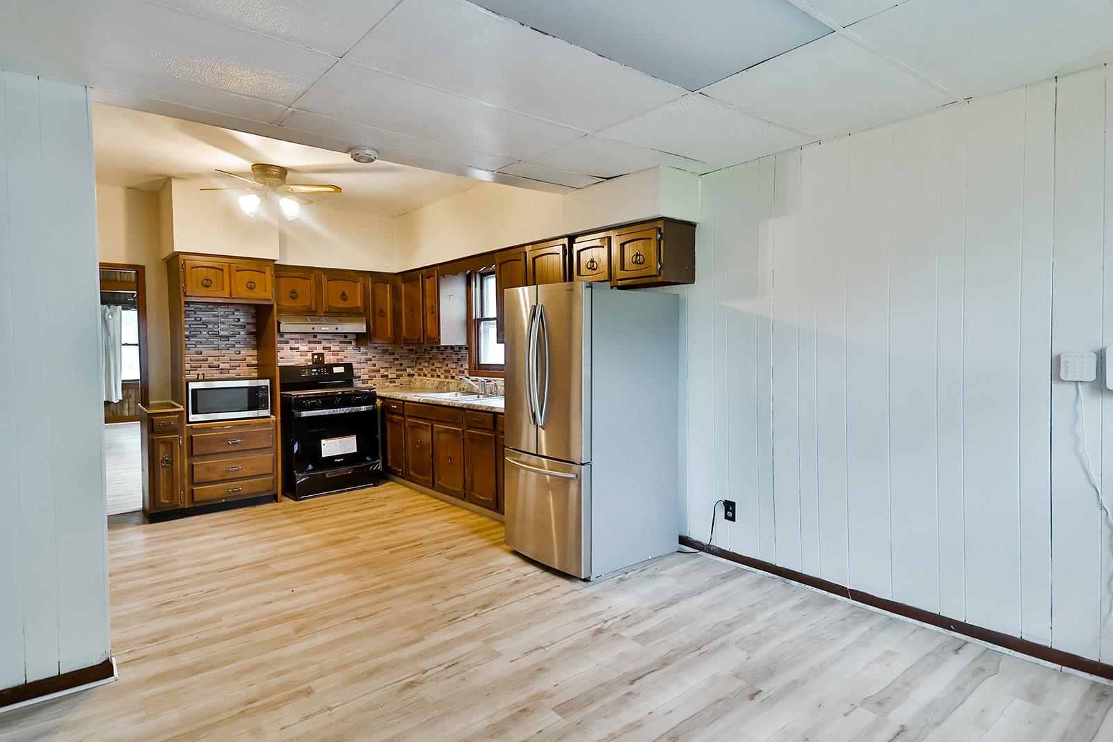 407 Barnum Road Rockford, IL 61109 - Photo 14 of 26 a kitchen with stainless steel appliances a refrigerator and a wooden floor