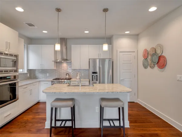 a kitchen with a center island refrigerator wooden floor and dining table