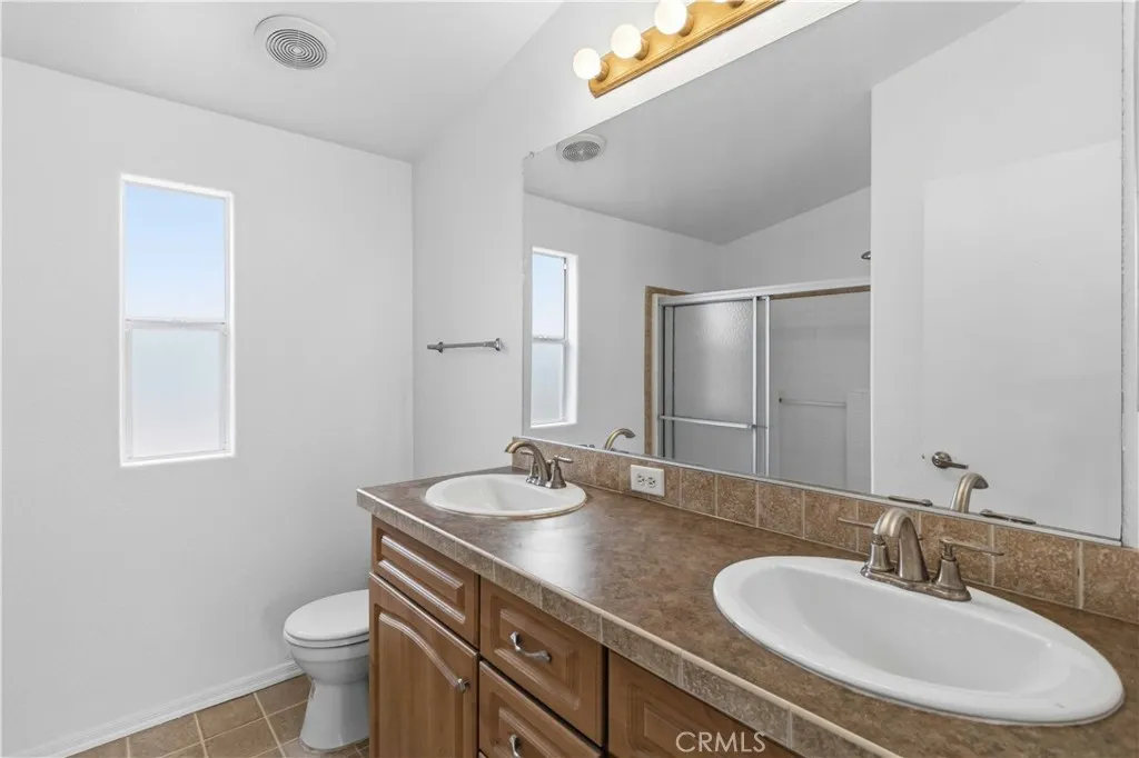 1550 Rory Simi Valley, Unit 133 Simi Valley, CA 93063 - Photo 24 of 29 a bathroom with a granite countertop sink a toilet and a mirror