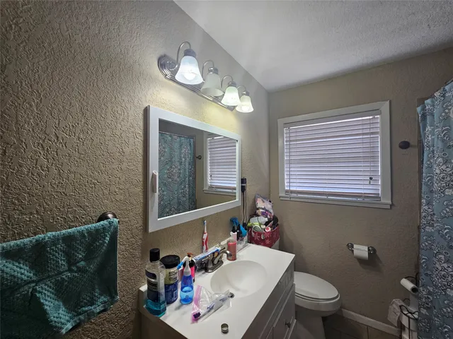 a bathroom with a sink mirror and toilet
