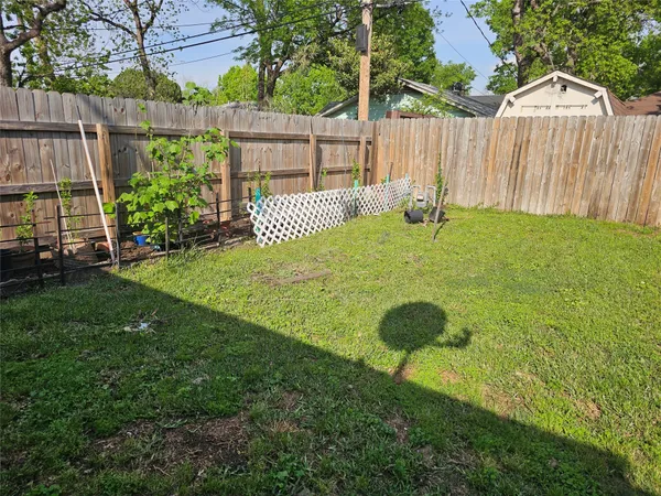 a view of a backyard with wooden fence and plants