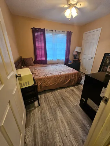a bedroom with a bed and wooden floor