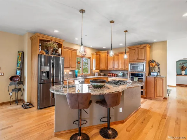a kitchen with stainless steel appliances granite countertop a stove and refrigerator
