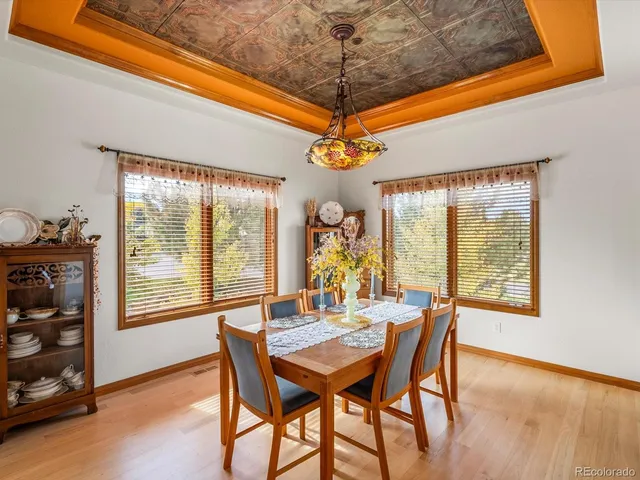 a dining room with furniture a chandelier and wooden floor