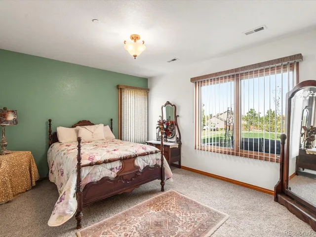 a bedroom with a bed and a lamp next to a window