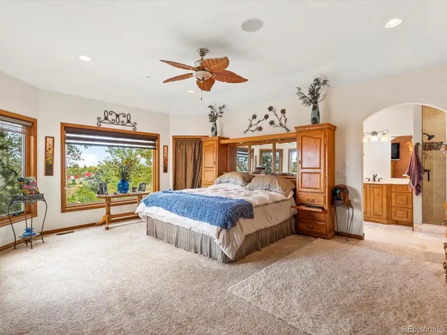 a bedroom with a bed and large windows