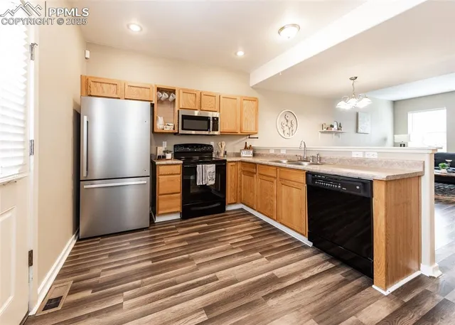 a kitchen with stainless steel appliances granite countertop a refrigerator and a stove top oven
