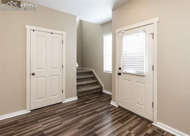 a view of a hallway with wooden floor and entryway